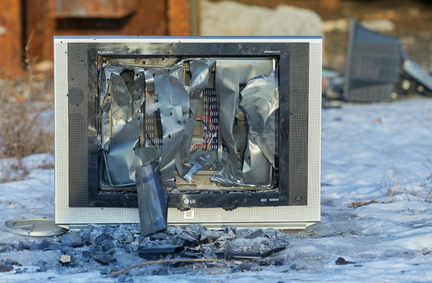 a broken television sitting on top of snow covered ground