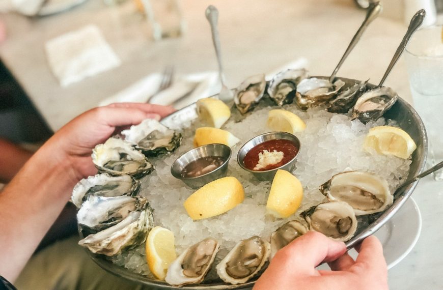 person holding plate with oysters