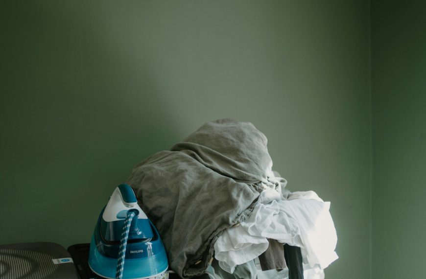 Iron and pile of clothes on ironing board