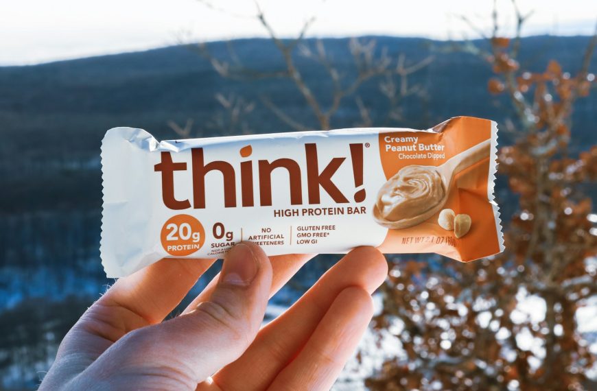 a hand holding a bar of think with a mountain in the background