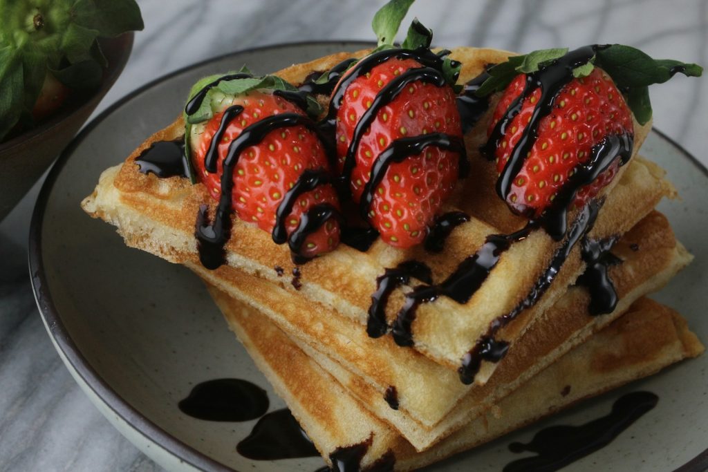 a stack of waffles with chocolate drizzled on top