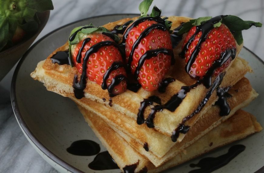 a stack of waffles with chocolate drizzled on top