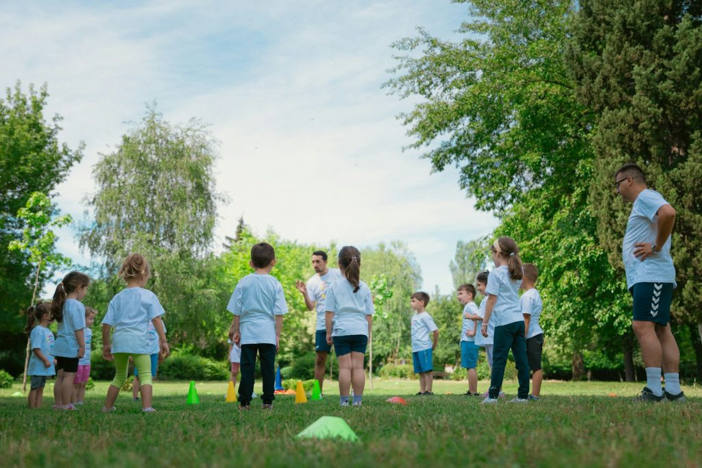 a group of people standing on top of a lush green field