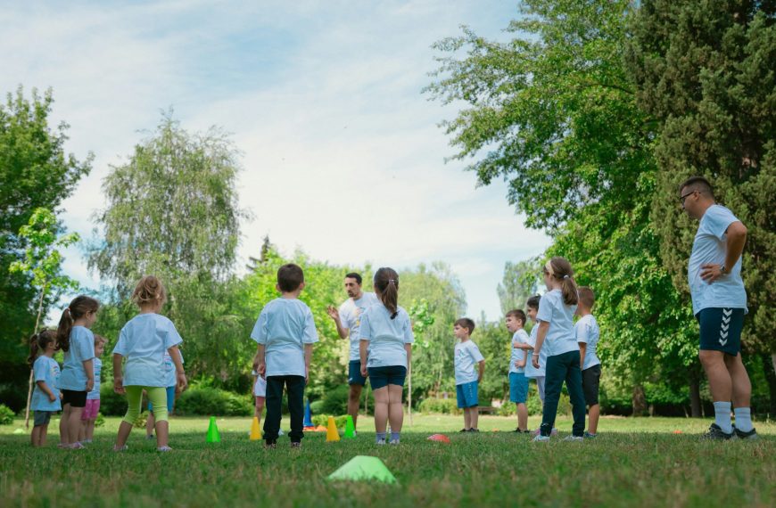 a group of people standing on top of a lush green field