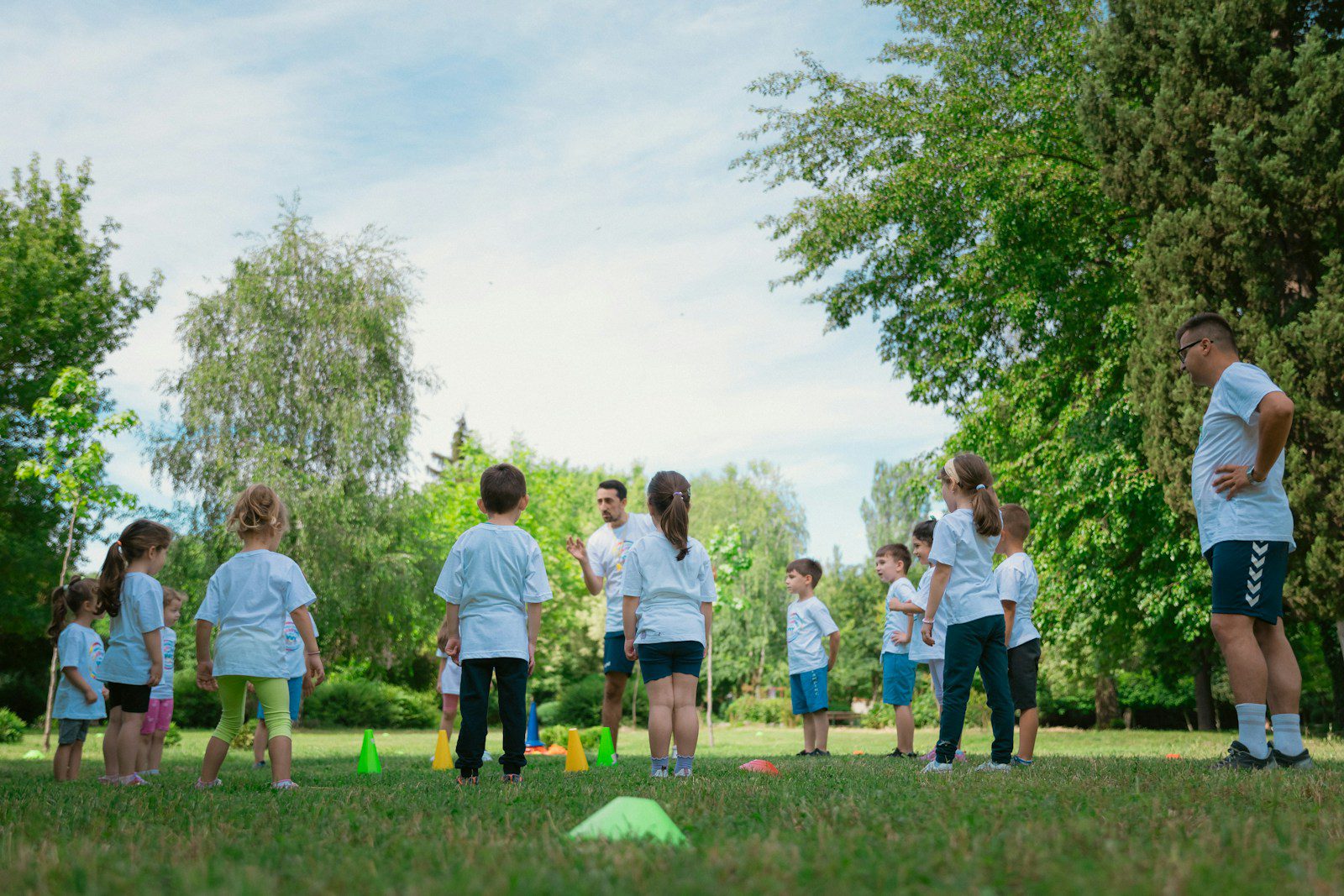 a group of people standing on top of a lush green field