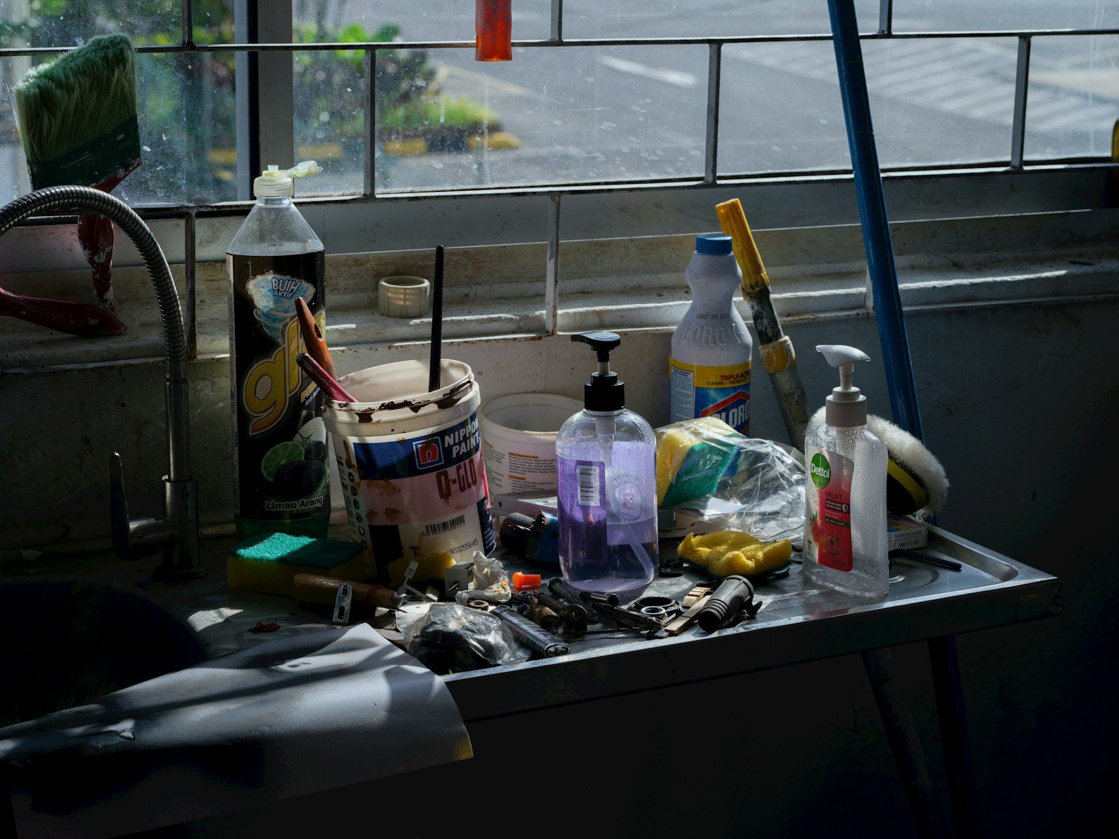 Various cleaning supplies and tools on a shelf.
