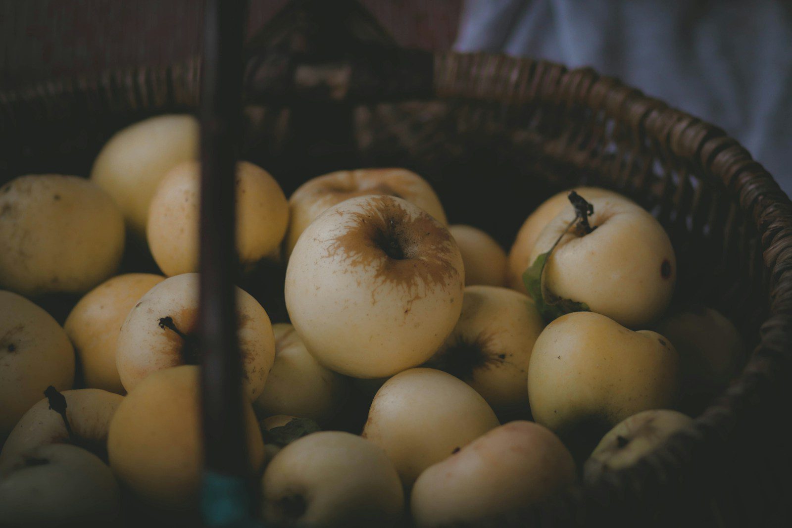 a basket filled with lots of yellow apples