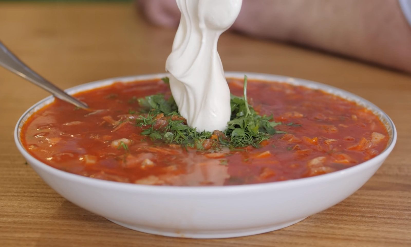 a bowl of soup with sour cream on top