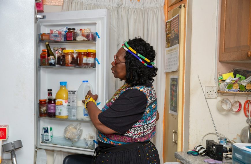a woman standing in front of an open refrigerator