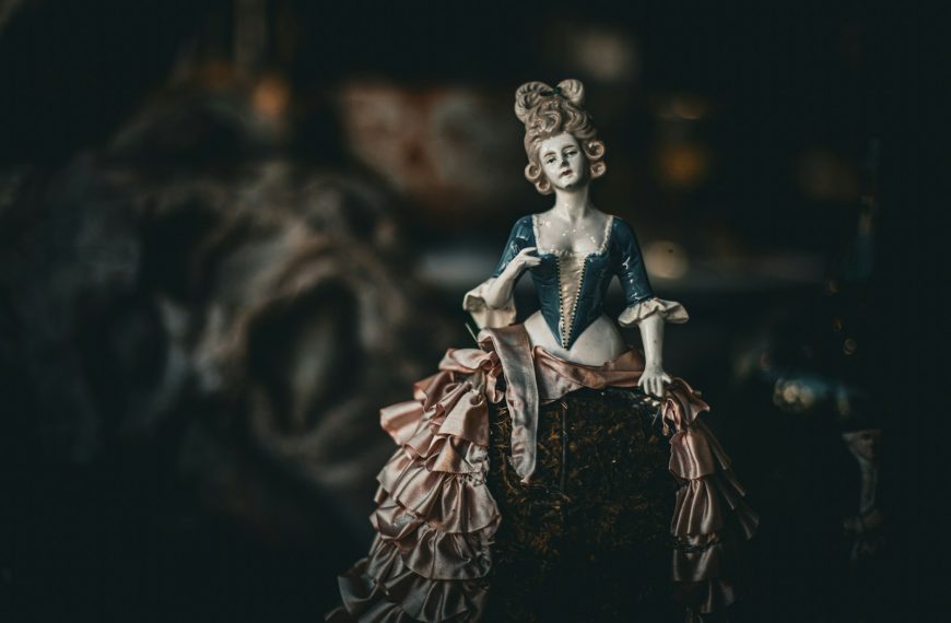 Antique doll with elaborate ruffled dress and hairstyle.