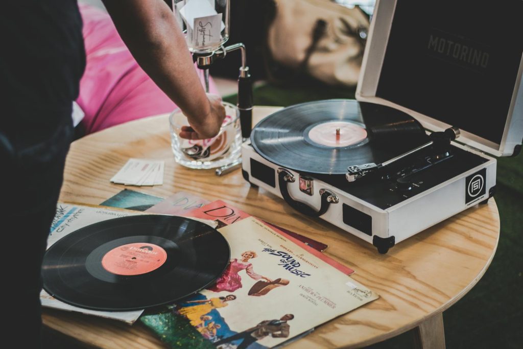 Close-up of a vinyl record player with classic albums, showcasing vintage music vibes.