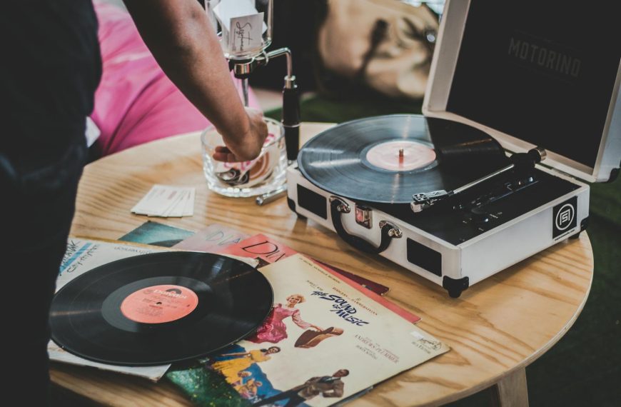 Close-up of a vinyl record player with classic albums, showcasing vintage music vibes.