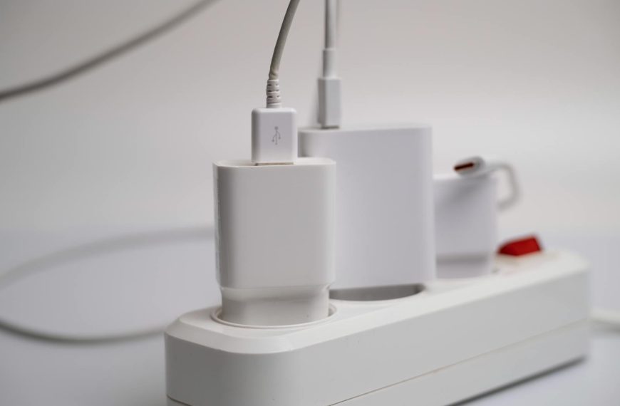 Minimalist composition of electronic device chargers connected to a power strip indoors.