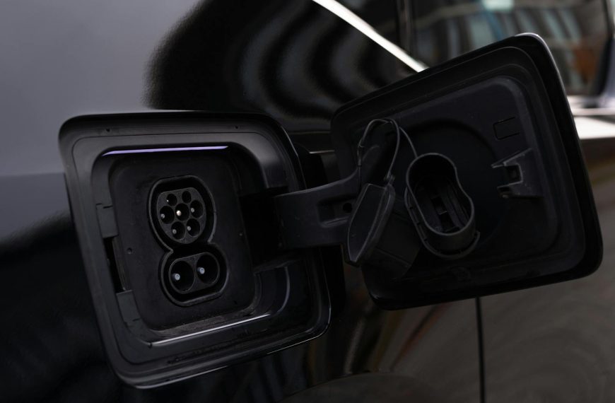Close-up image of an electric vehicle charging port on a black car.
