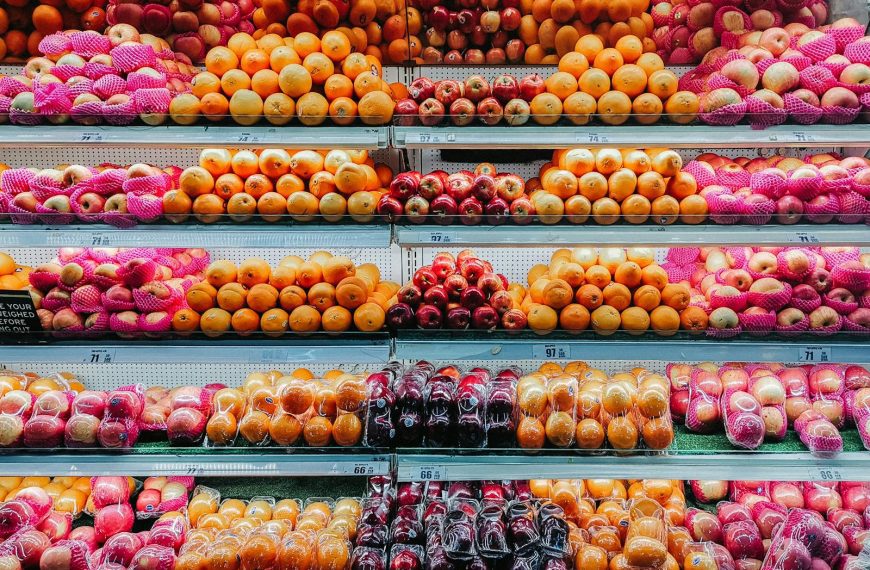 Colorful variety of fresh fruits neatly arranged on supermarket shelves, showcasing abundance and freshness.