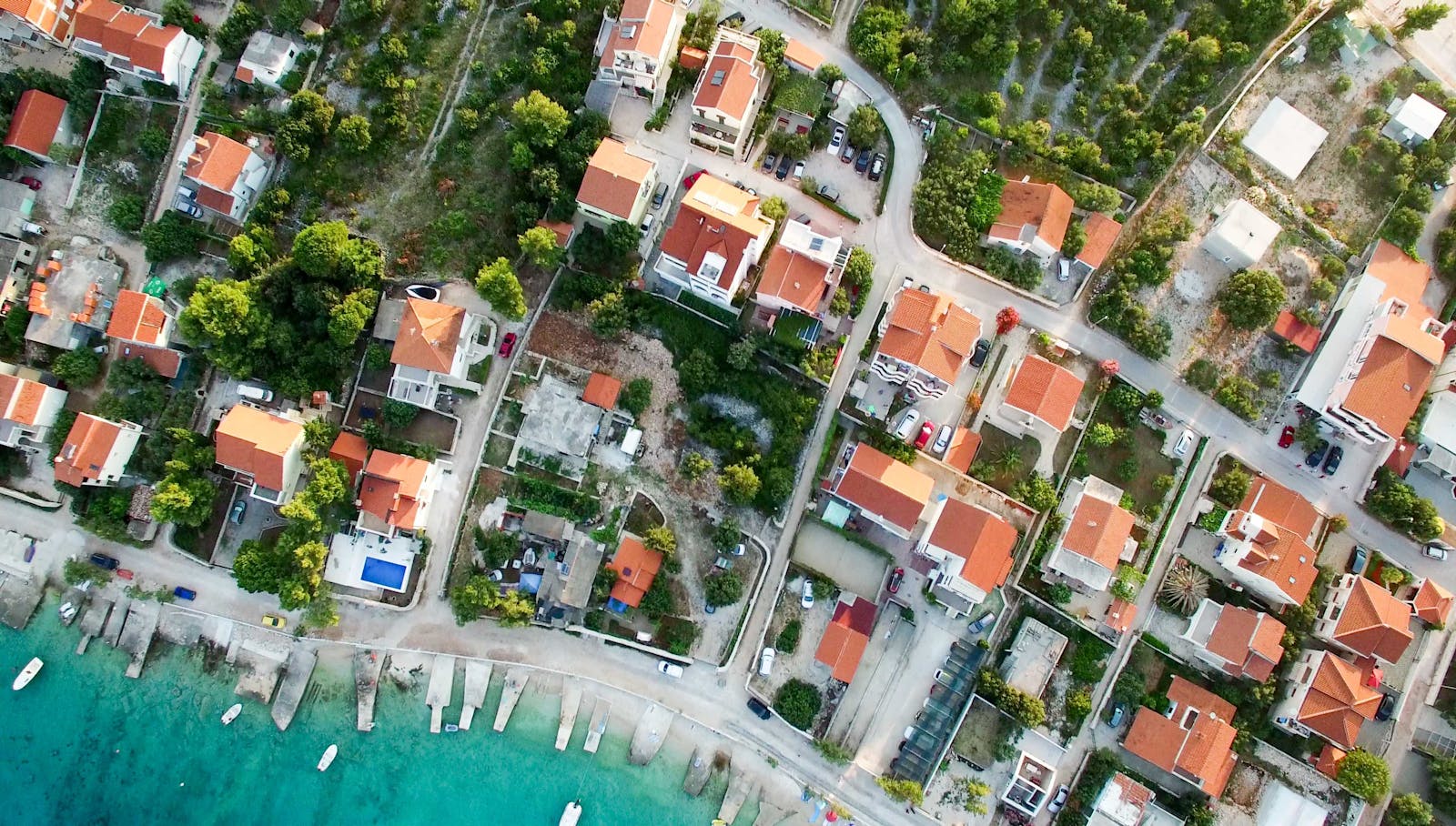 A scenic aerial shot of a seaside town in Croatia featuring rooftops and clear blue waters.