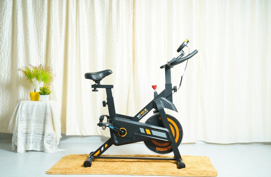 a stationary bike sits on a rug in front of a curtain