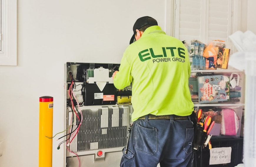A technician from Elite Power Group installing a home battery system indoors in New South Wales, Australia.