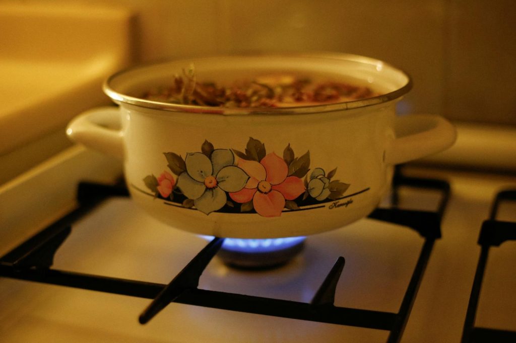 A vintage floral pot simmering on a gas stove, filling the kitchen with warmth.