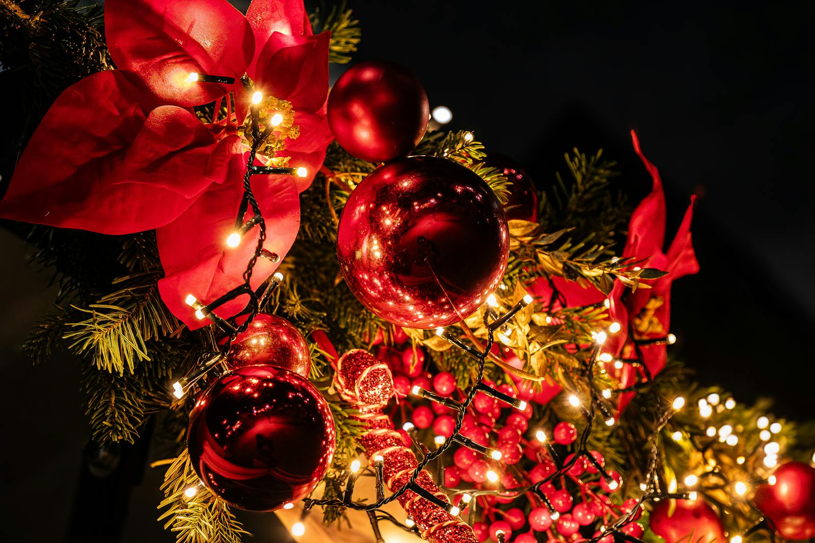 Vibrant Christmas garland with lights and baubles in Paris, capturing holiday spirit.