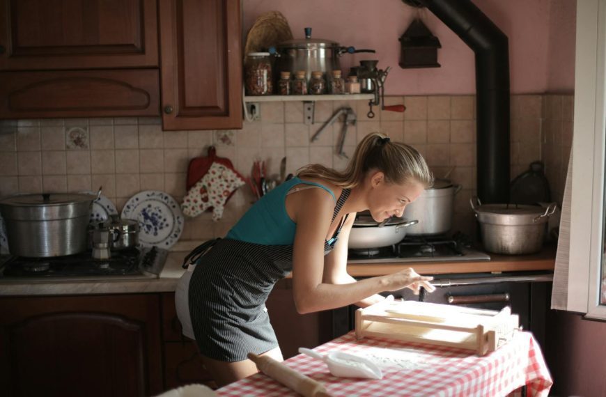 A woman baking in a rustic kitchen with sunlight streaming, creating a cozy morning vibe.