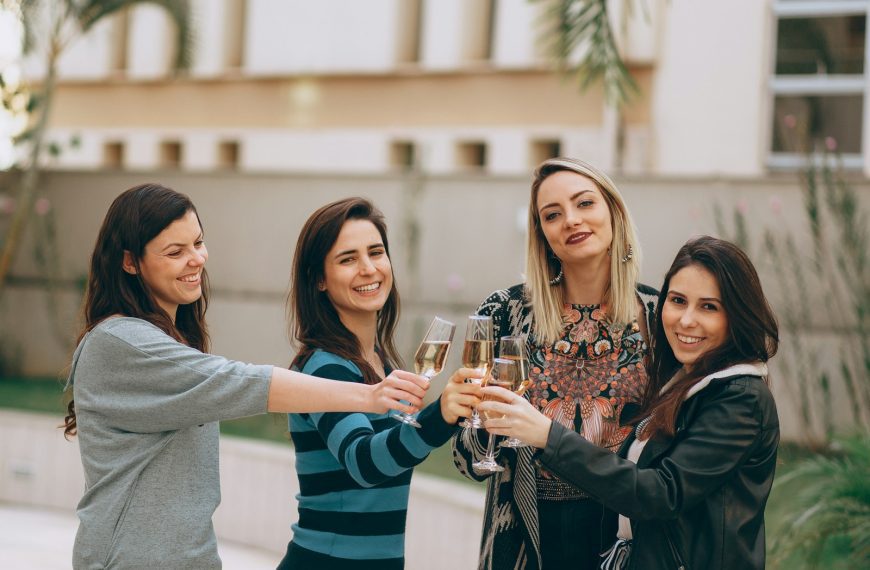 2 women smiling and holding drinking glass