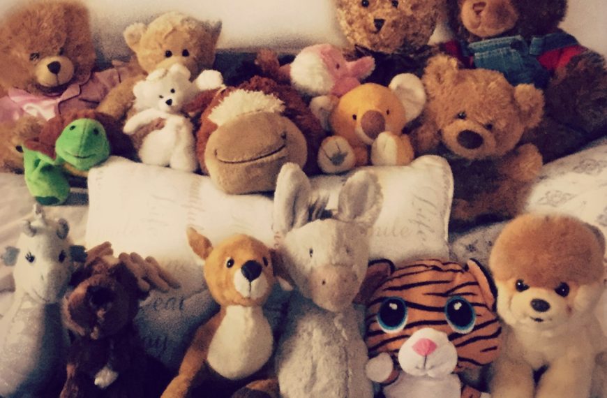 brown bear plush toy on white textile