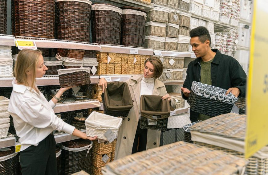 A diverse group of adults selecting wicker baskets in a retail store aisle.