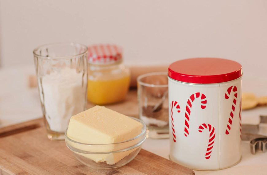 A cozy setup for holiday baking featuring butter, flour, and festive candy cane jars.