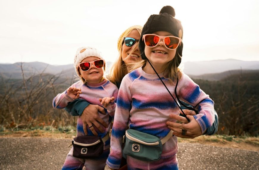 Family enjoying a sunny day outdoors in Asheville, NC, with kids wearing colorful outfits and sunglasses.