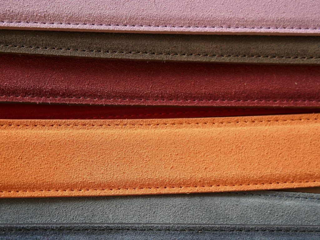 Close-up of colorful leather belts showcasing detailed stitching.