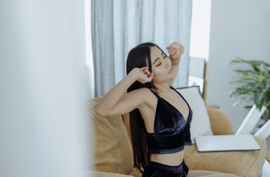 Woman with long hair stretches indoors, embracing a calm morning routine. Perfect for lifestyle and wellness themes.