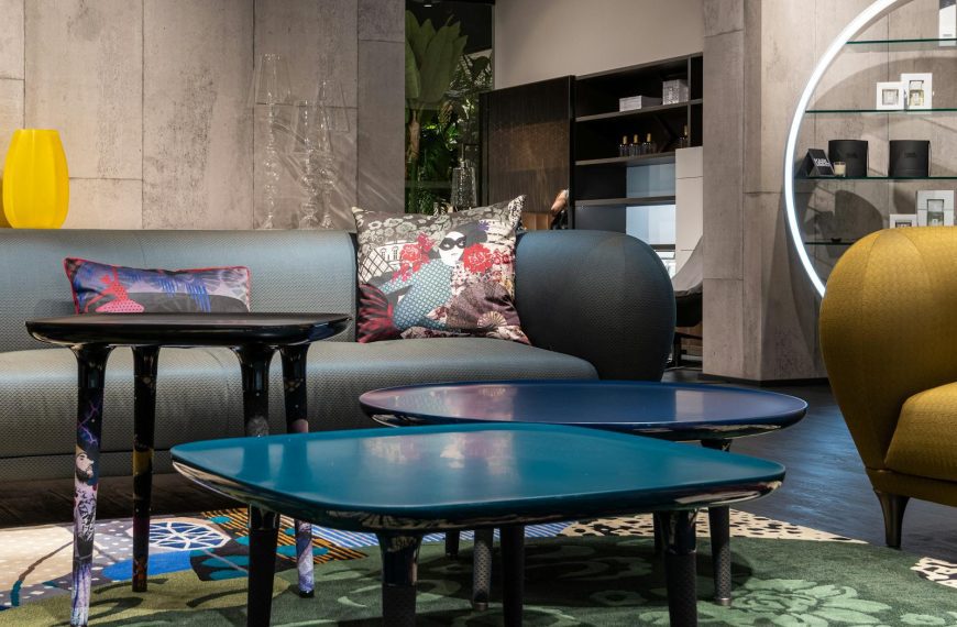 Comfortable couch with cushions placed on carpet near stylish tables in modern living room