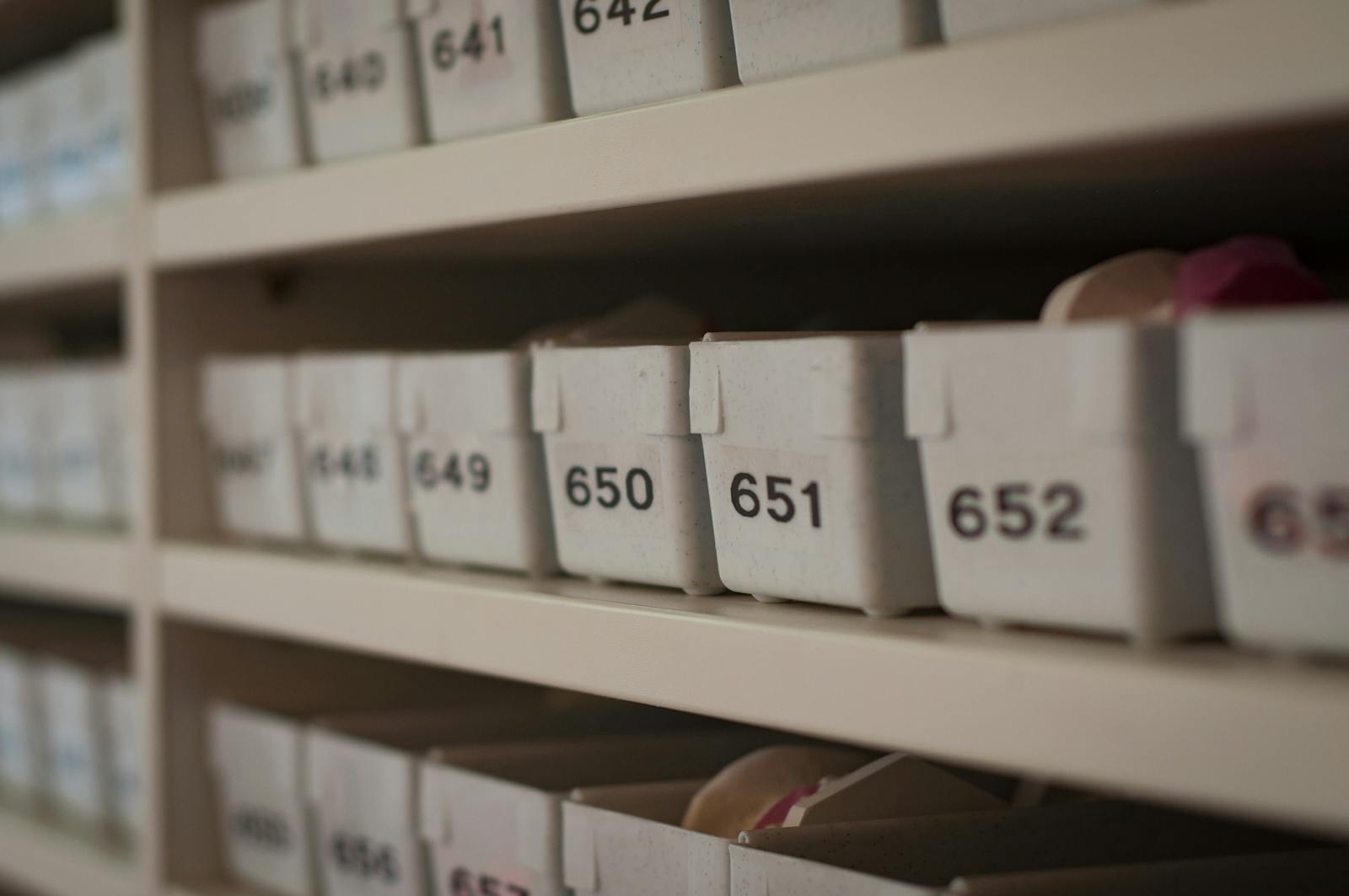 Close-up of numbered storage containers on shelves in an organized setting.