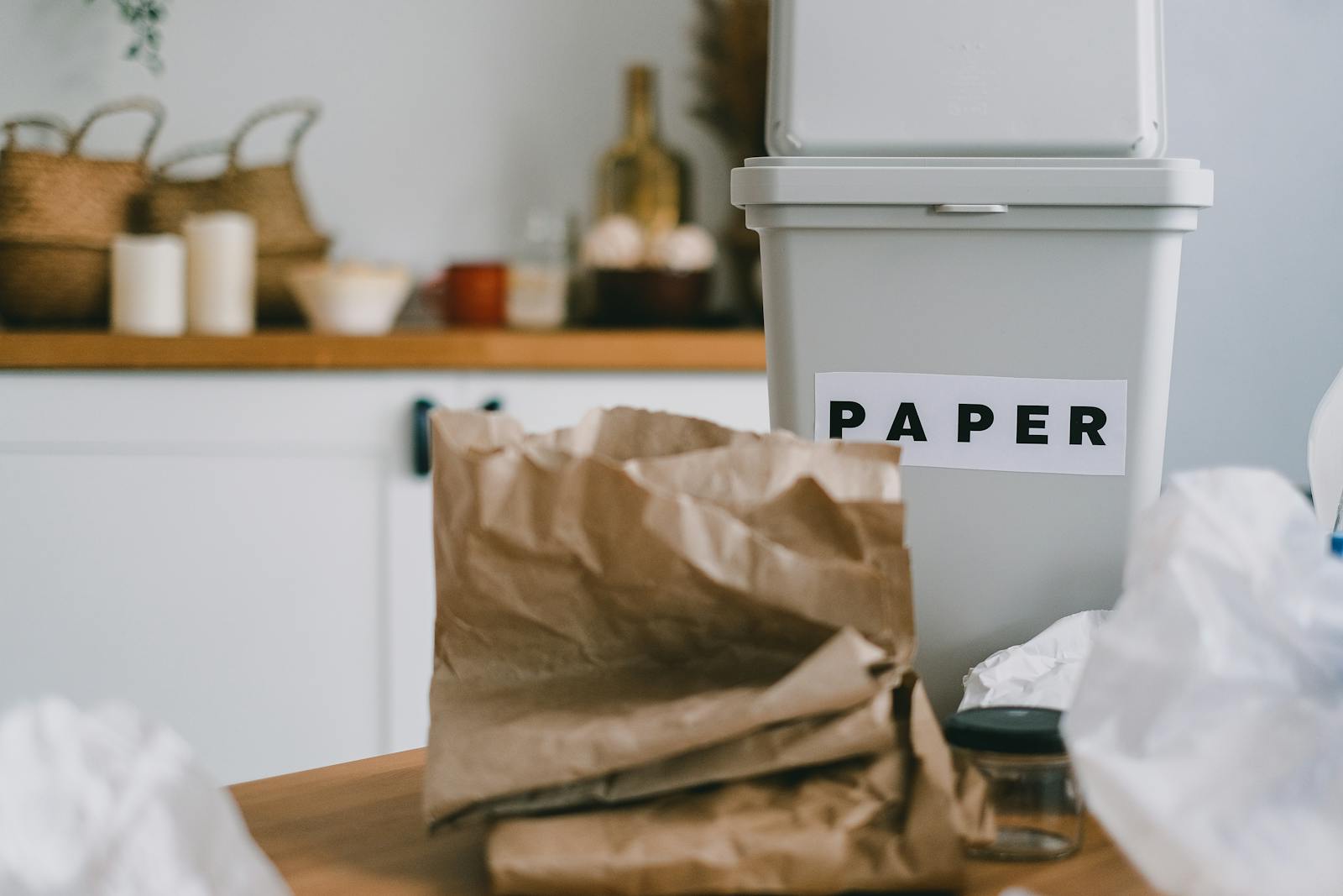 Close-up of a paper recycling bin in a messy kitchen, promoting zero waste and sustainability.