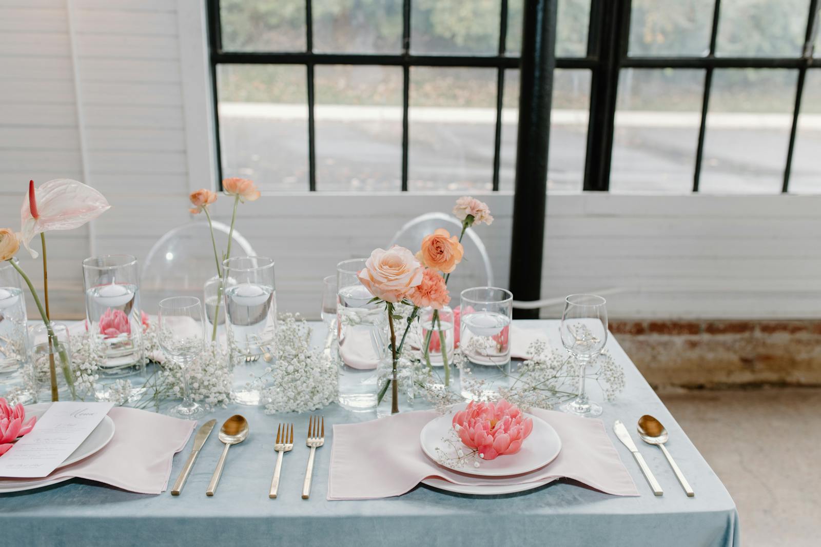 A beautifully arranged table with delicate flowers and elegant dinnerware, perfect for special occasions.