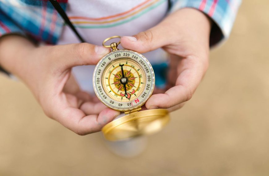 A detailed view of hands holding a vintage compass, suggesting exploration and guidance.