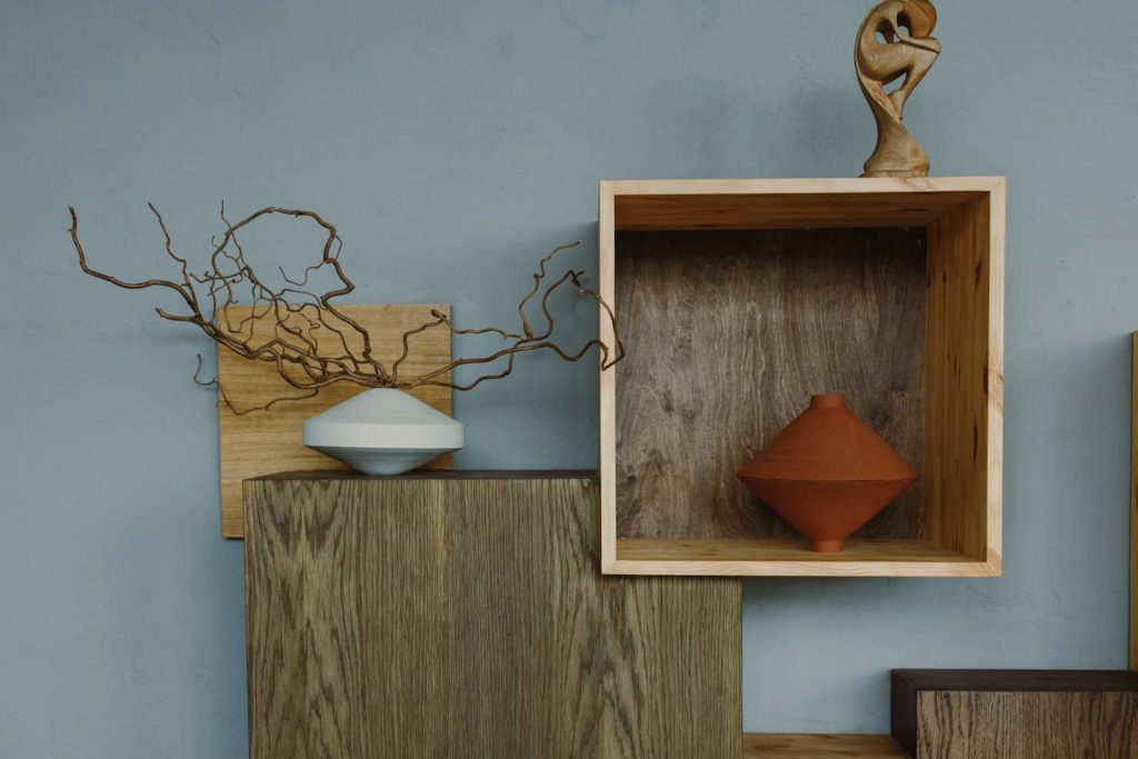 Stylish interior featuring ceramic vases on wooden shelves and artistic decor elements.