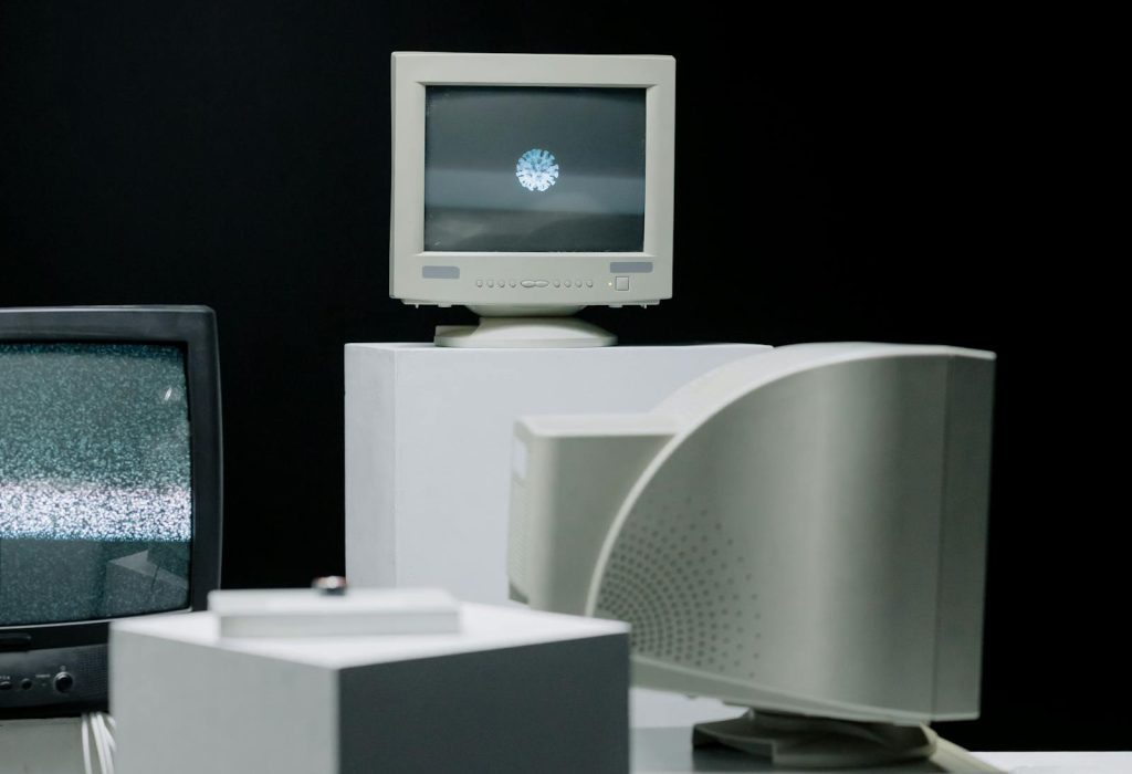 Vintage monitors displayed with static screens in a dark studio setting.