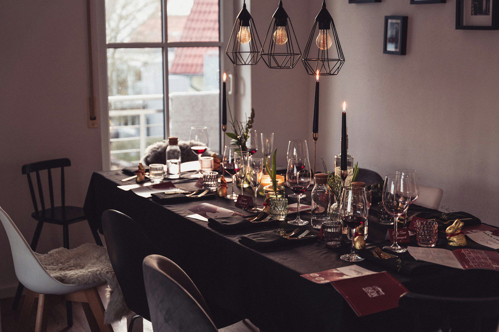 a dining room table is set with wine glasses and place settings