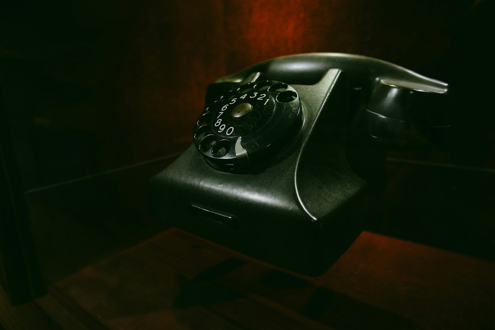 Vintage rotary dial telephone on a dark surface.