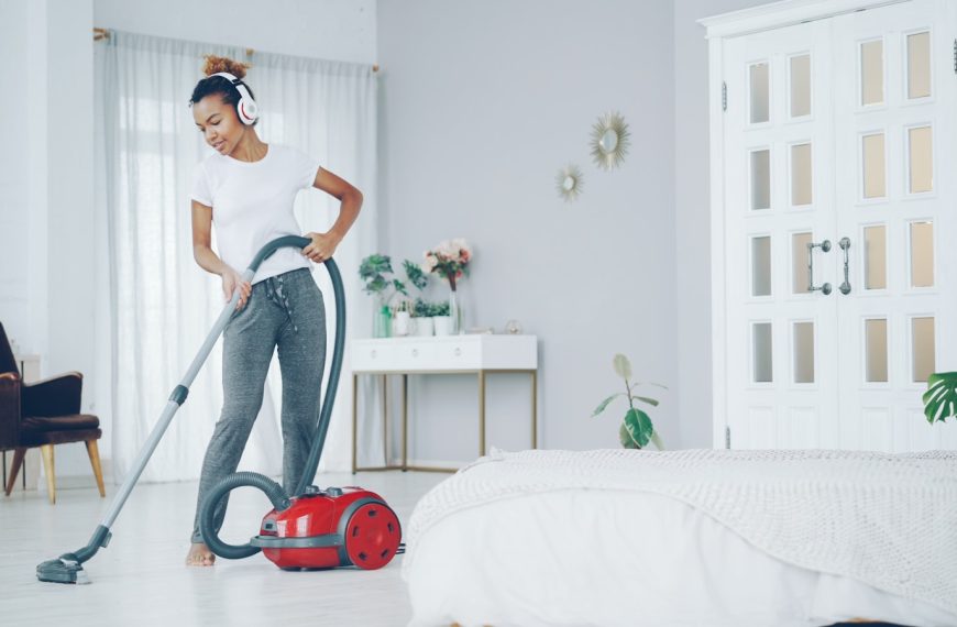 Woman dancing while vacuuming in a bright room