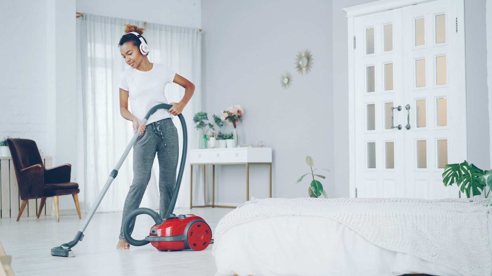 Woman dancing while vacuuming in a bright room