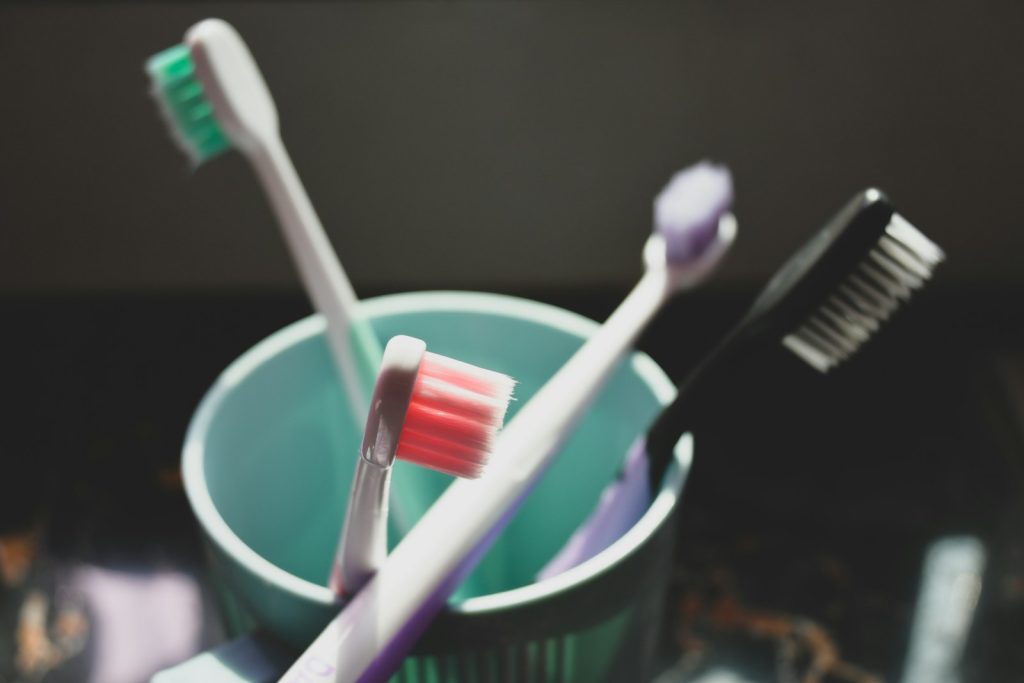 two toothbrushes in a cup with toothpaste