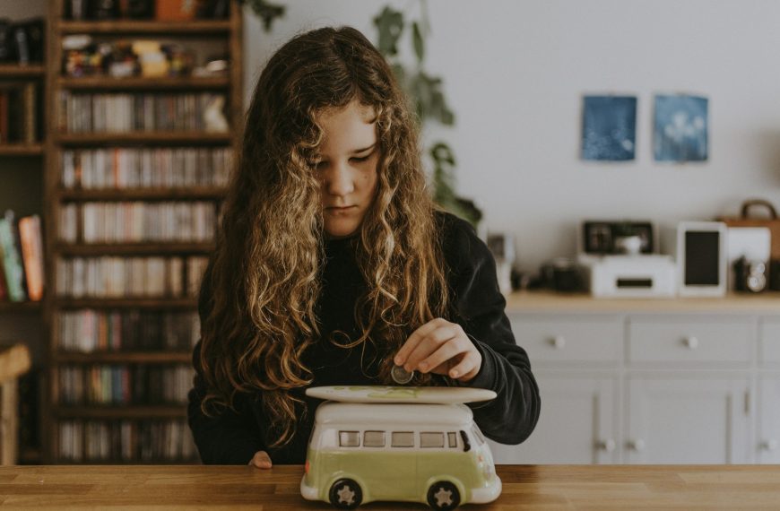 girl wearing black sweatshirt playing toy car