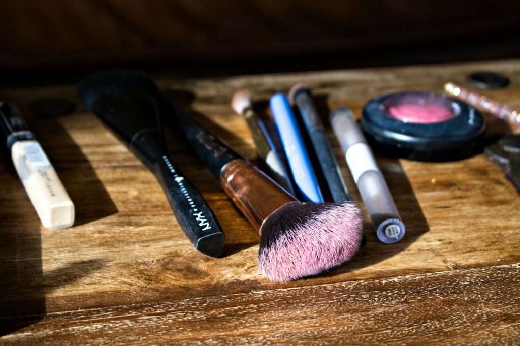 black and brown makeup brush on brown wooden table
