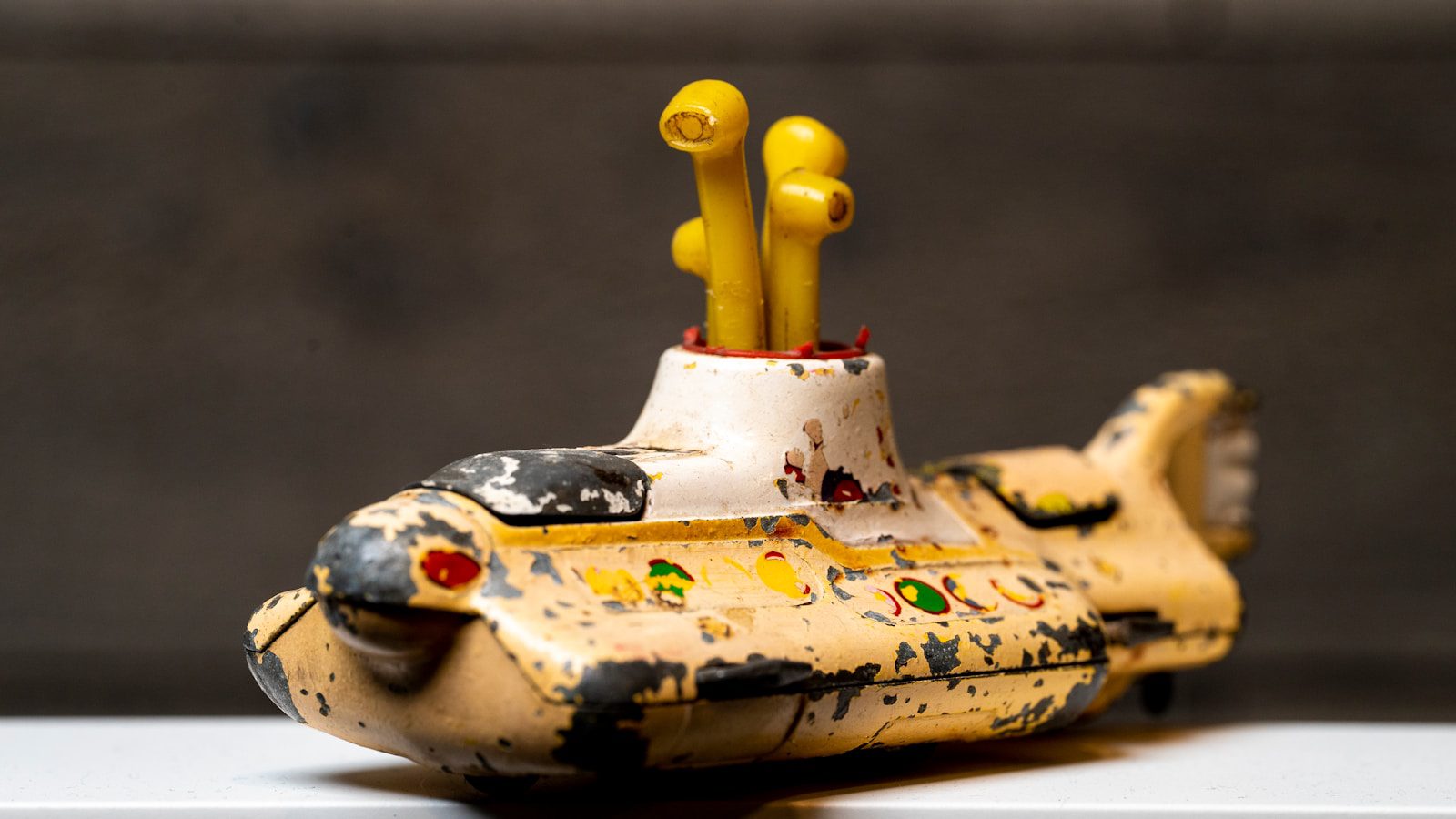 a yellow toy submarine with yellow sticks sticking out of it
