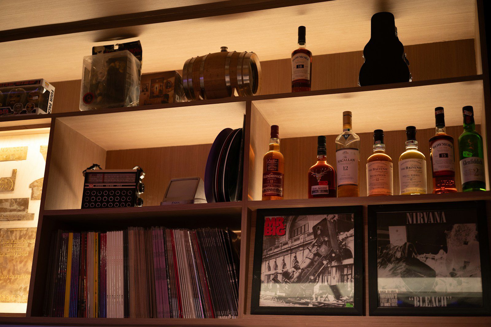 Bottles and records displayed on wooden shelves.