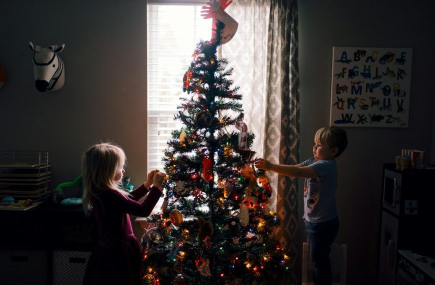 girl and boy standing near Christmas tree