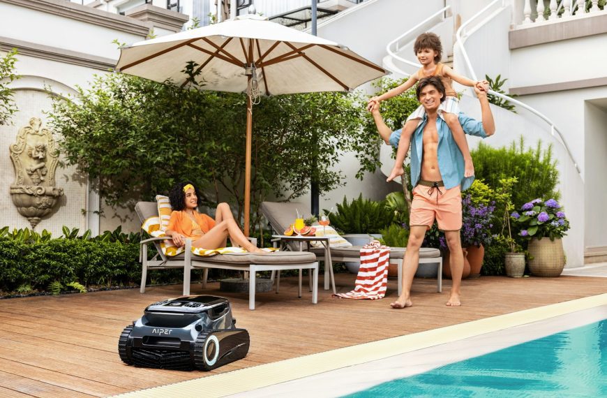 A couple of people standing next to a pool